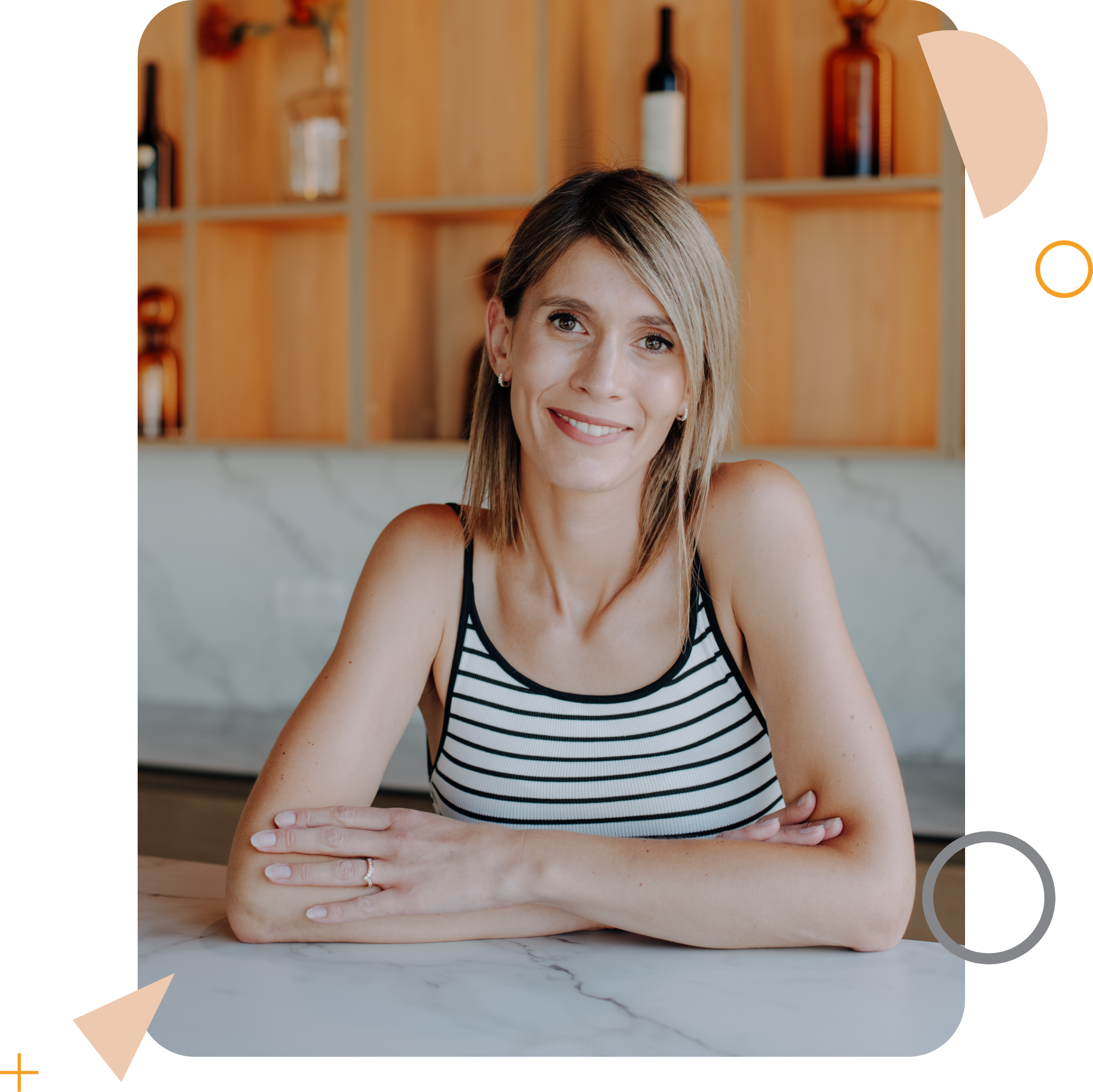 Portrait d’une femme souriante, assise à une table.