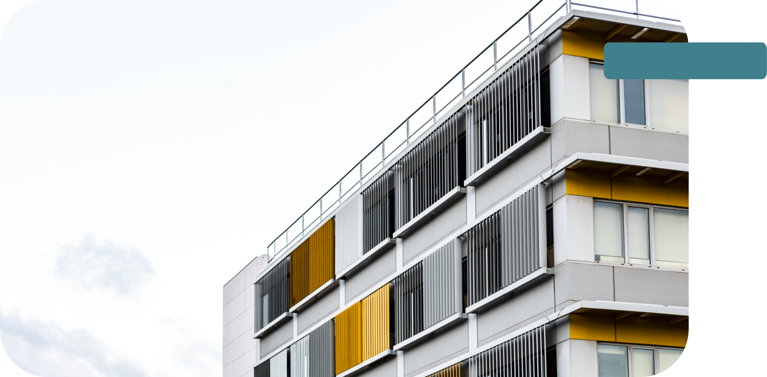 Façade d’un immeuble contemporain aux balcons gris et jaunes.