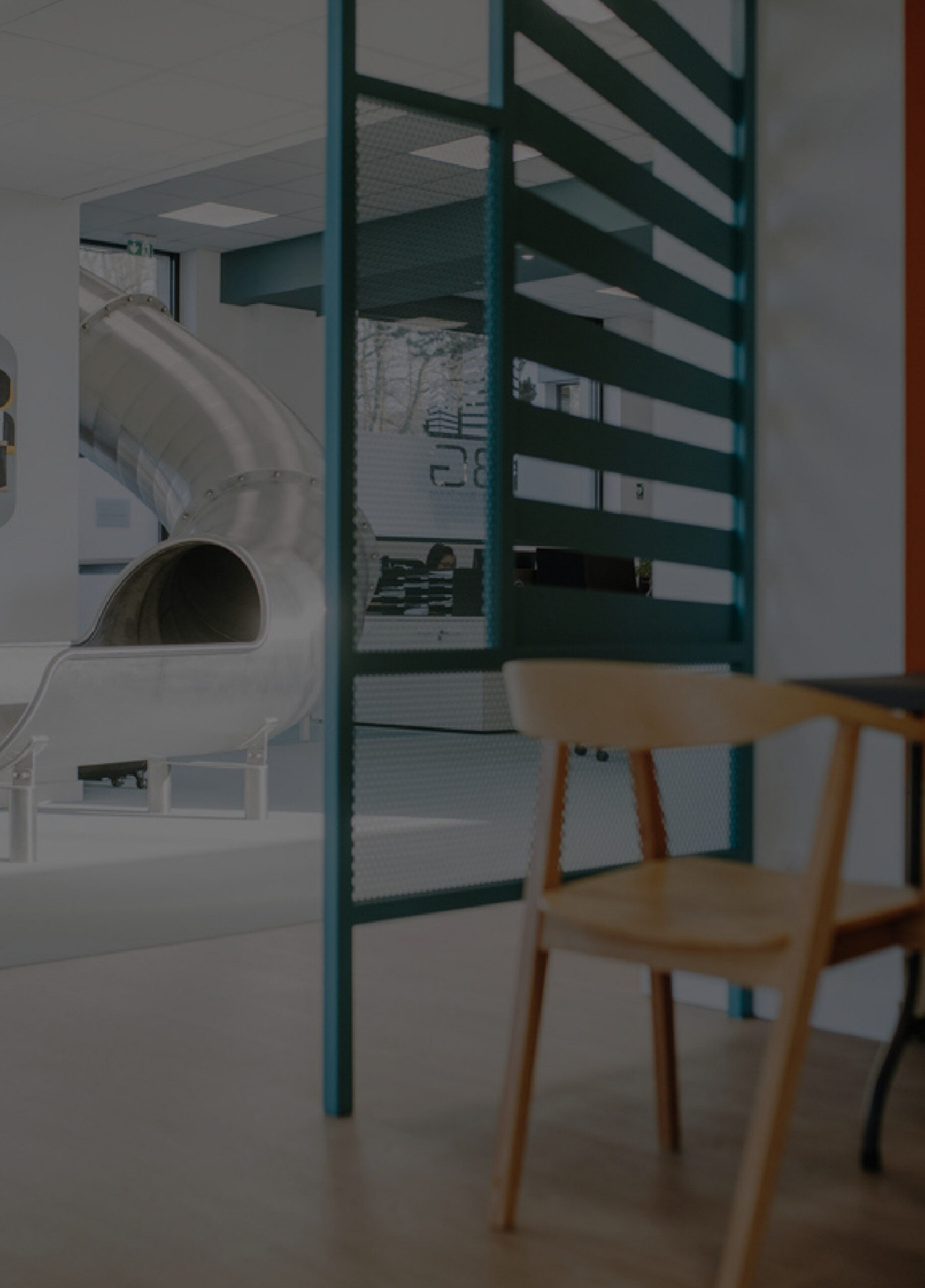 L'intérieur des bureaux IBG, avec une cloison vitrée et un fauteuil