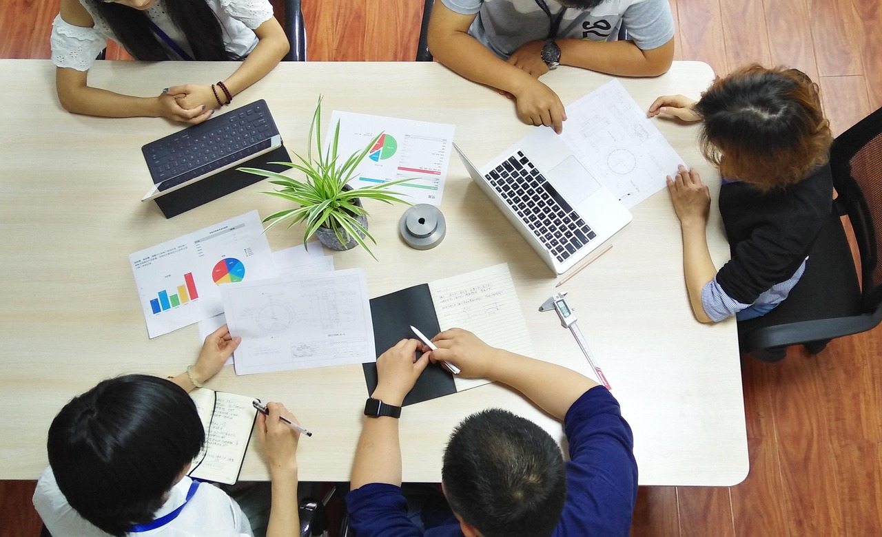 Des participants examinent des plans et des graphiques autour d'une table